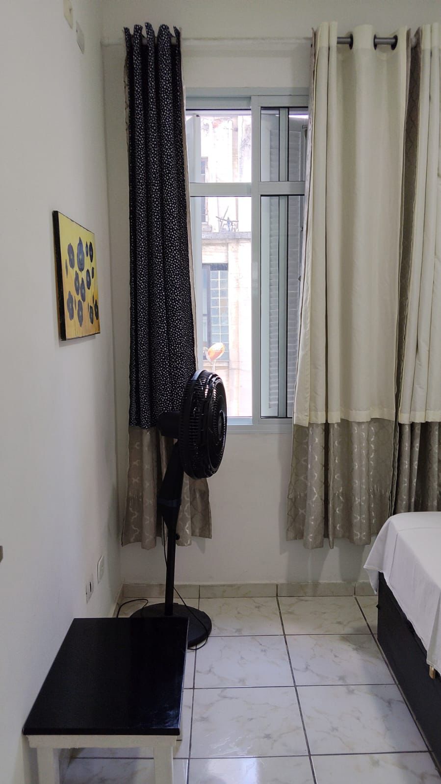 Suíte privativa com cama de casal, enxoval branco e ambiente acolhedor